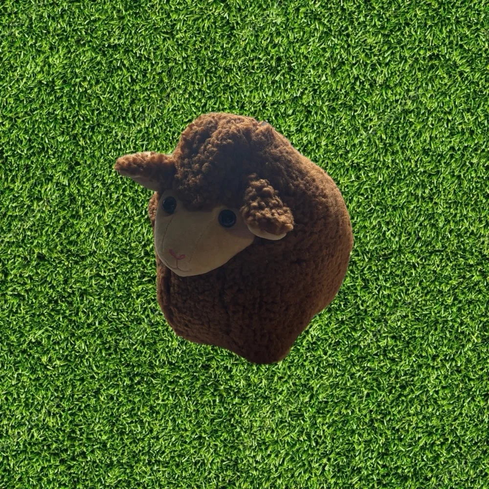 sheep-shaped plush pillow or cushion made from textured teddy or bouclé fabric.